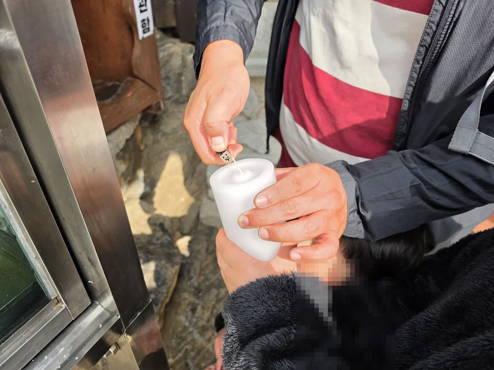낙산사에서 가족을 생각하며 초에 불을 밝히는 모습
