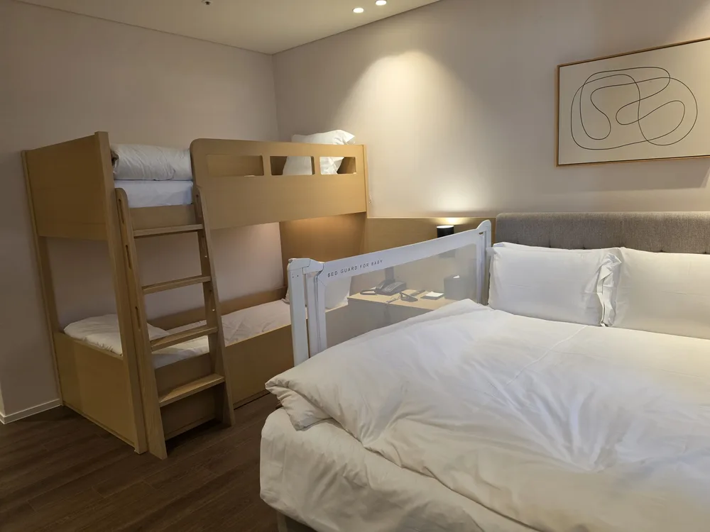 더블 침대 옆에 이층 벙커 침대가 놓인 신라스테이 전주 객실