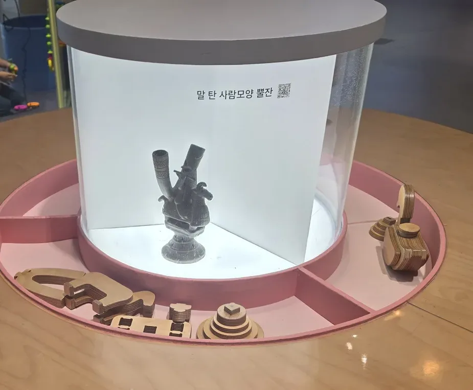 말 탄 사람모양 뿔잔을 살펴보고 나무 조각을 맞추는 체험 탁자